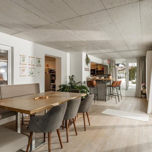 Bright open dining area with wooden table and gray chairs
