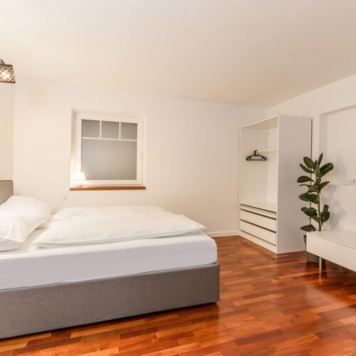 Modern bedroom with bed, wardrobe, and TV console