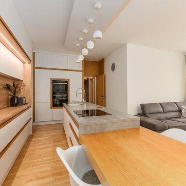 Modern kitchen with island, pendant lights, and living area