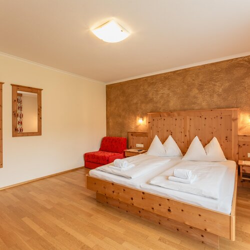 Wooden-furnished hotel room with a double bed