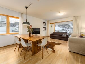 Bright open-plan living and dining room with wooden furniture