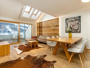 Bright open living and dining area with wood accents and large windows
