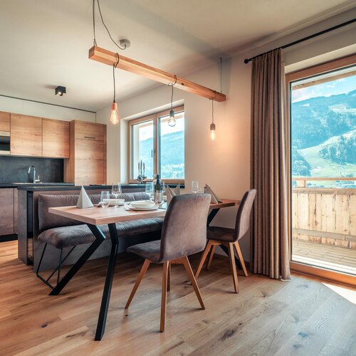 Open-plan kitchen and dining area with wooden furniture and mountain view