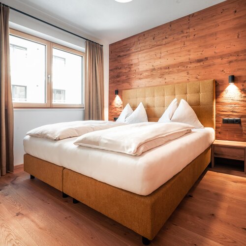 Bedroom with wooden accent wall and large bed