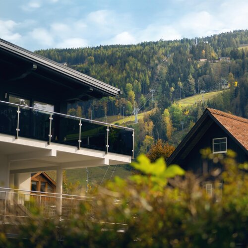 Modern house with glass balcony overlooking a hillside