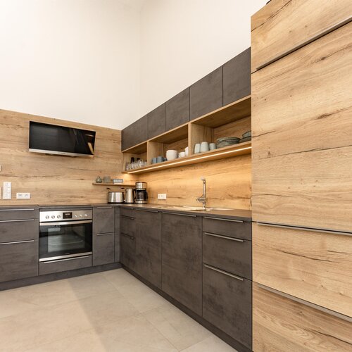 Modern L-shaped kitchen with wood and gray cabinets and open shelves
