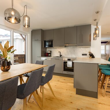 Modern kitchen with gray cabinets and wooden dining table